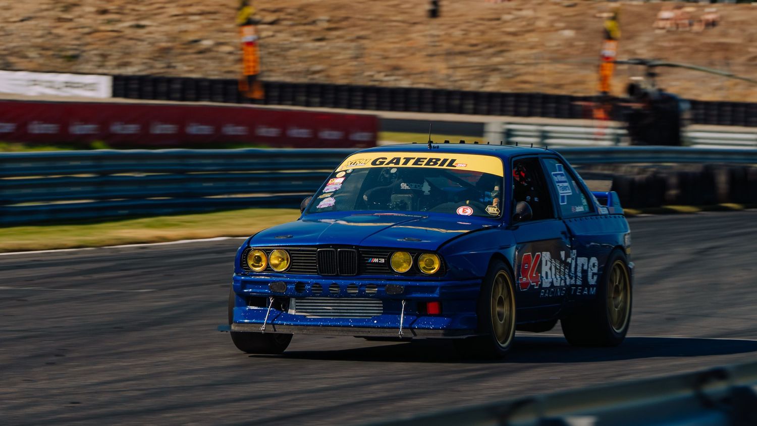 Professional race cars compete on a racetrack during a high-speed motorsport competition event.