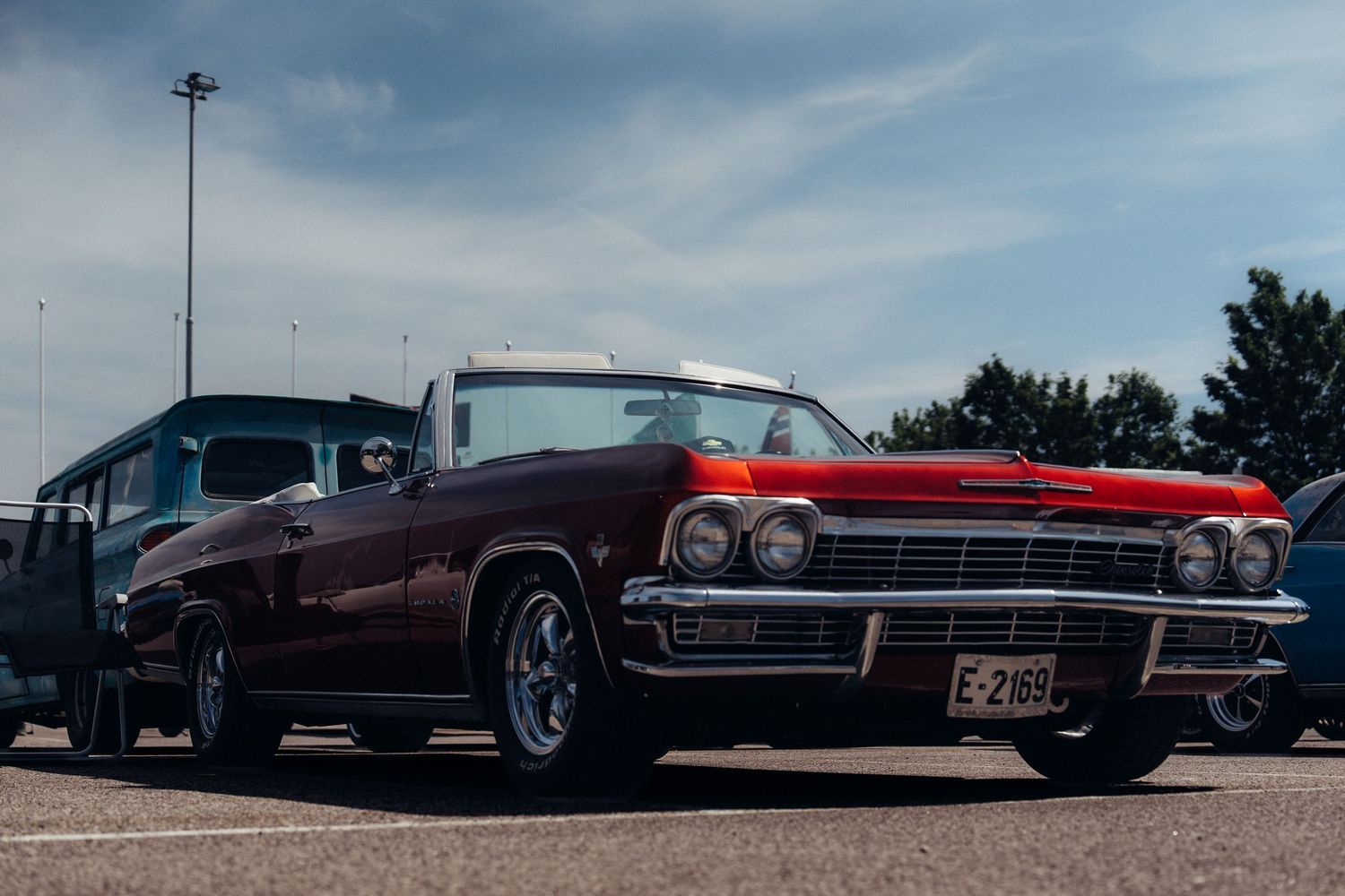 Row of vintage American cars showcasing their classic designs at an outdoor car show.