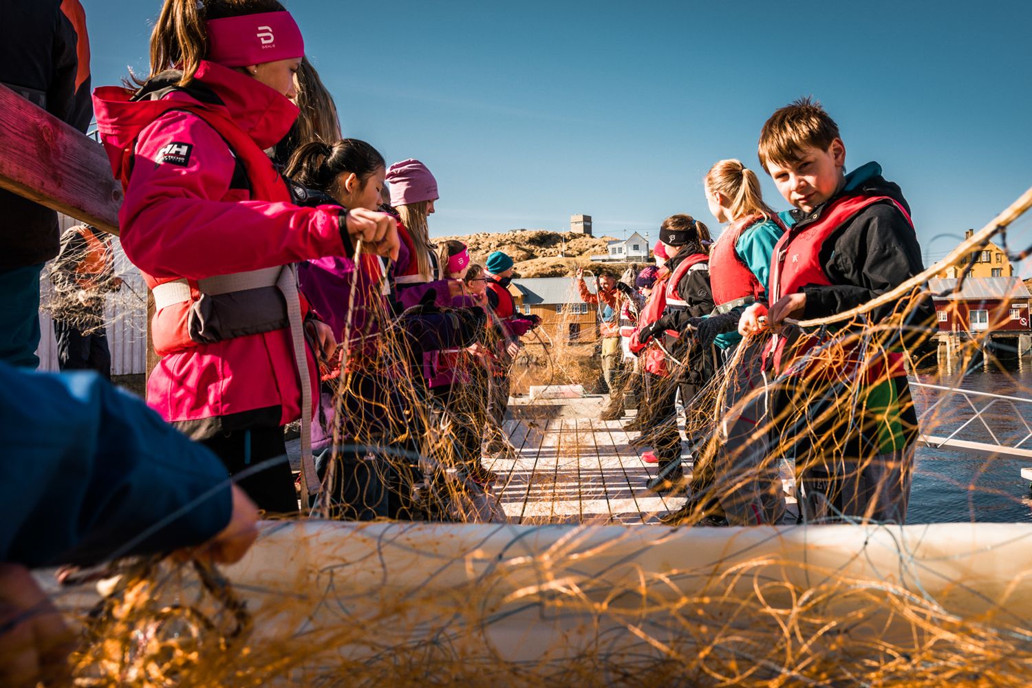 Winter activity gathering on wooden dock with colorful winter gear.