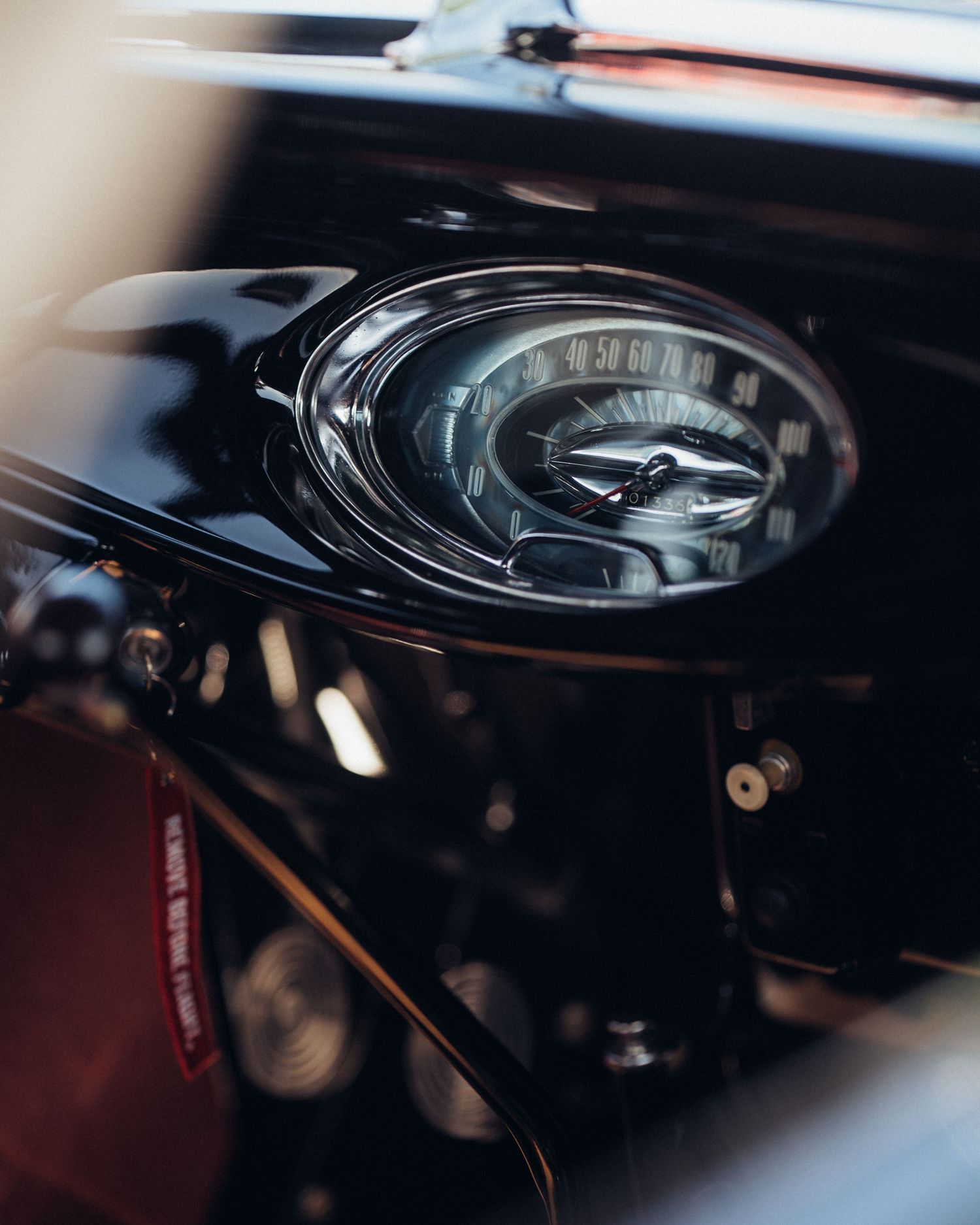 Close-up detail shot of a vintage car gauge cluster with chrome bezel.