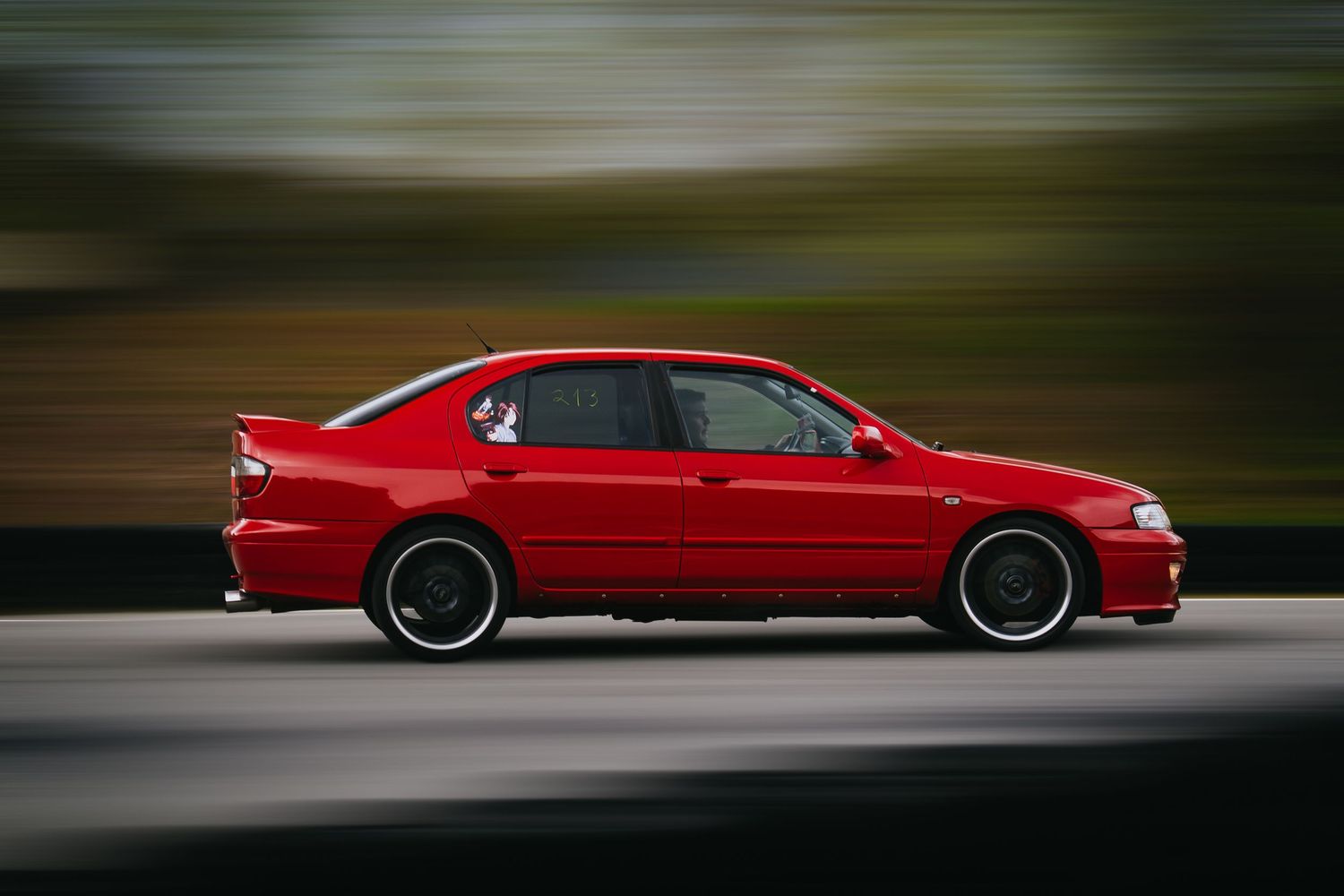 Red Nissan Skyline GT-R sports car shown in multiple dynamic angles with motion blur effects.