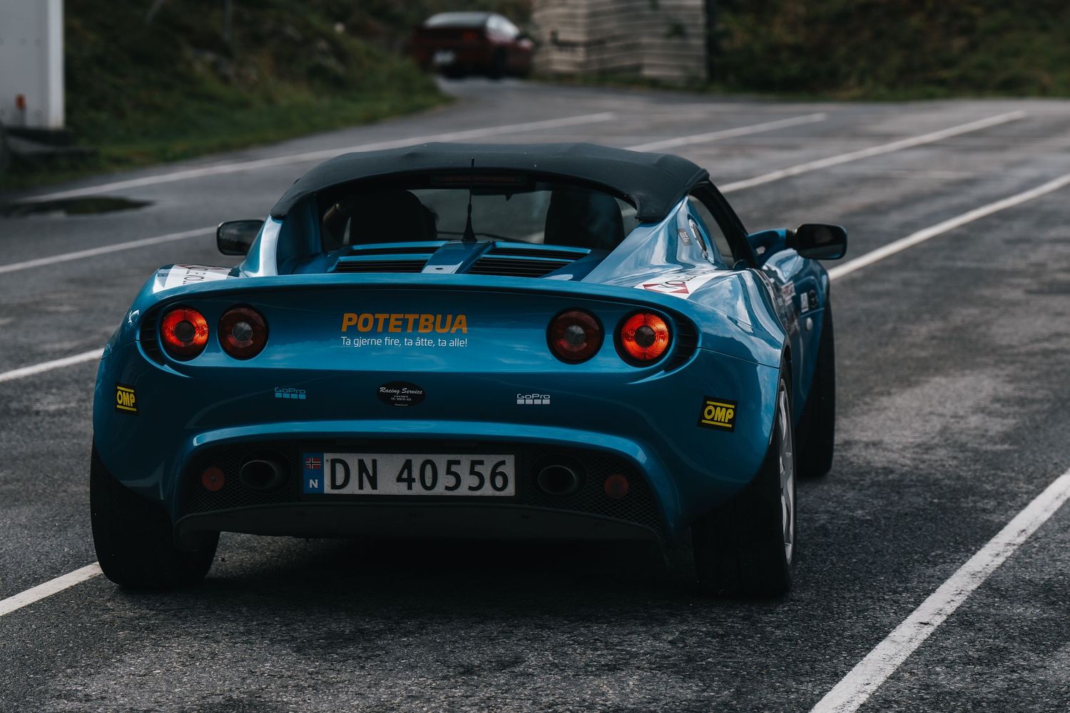 A vintage blue convertible sports car photographed from multiple angles on a winding mountain road.