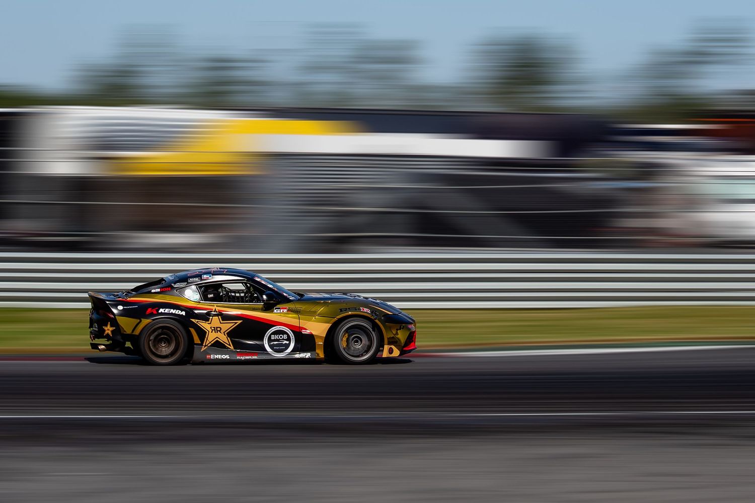 Formula 1 race cars speed past in motion blur on a racing circuit during a Grand Prix competition.