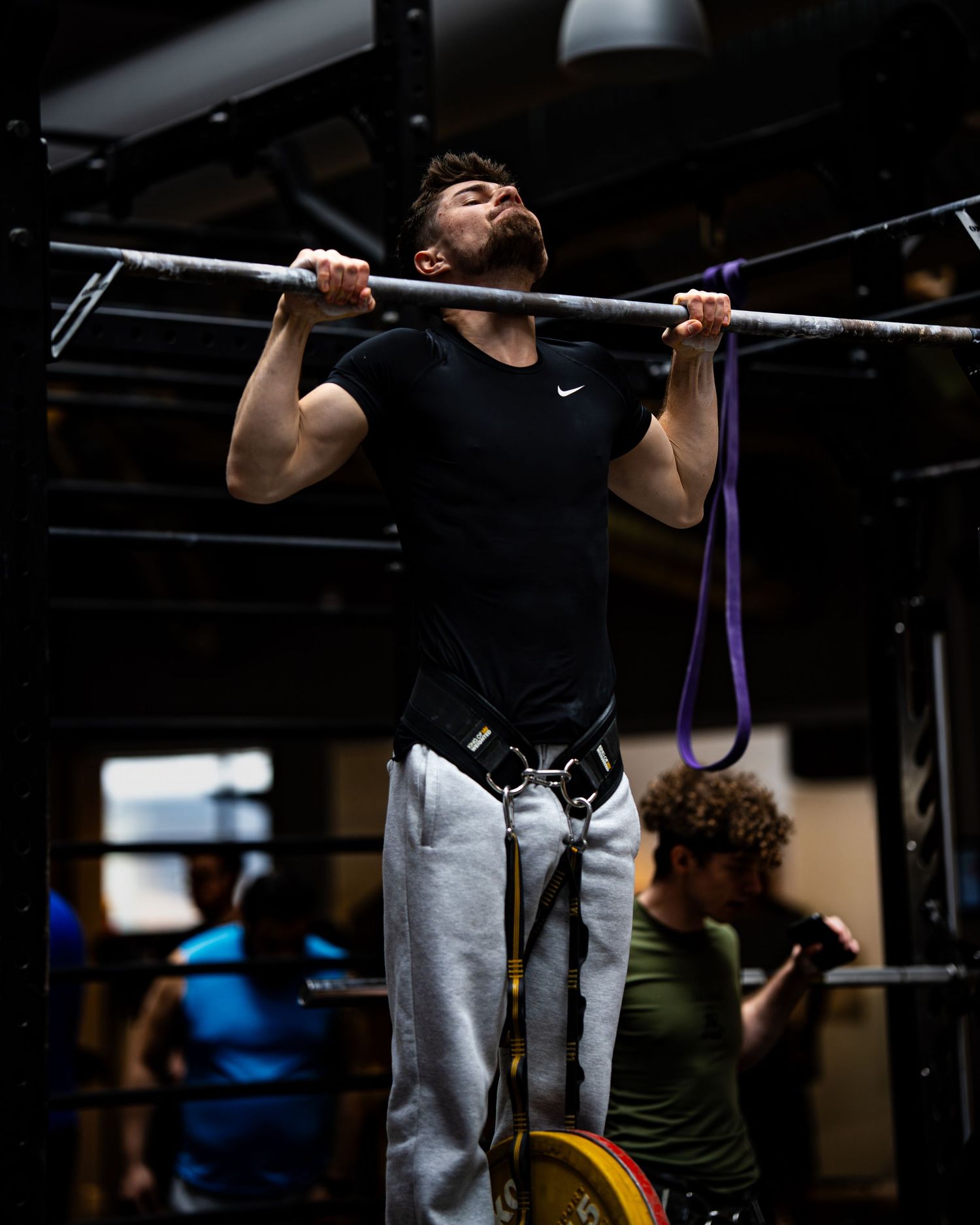 Athletes performing pull-ups during an intense gym training session.