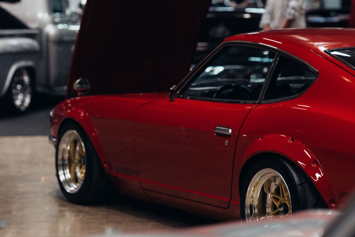Side view of classic red sports cars lined up in a showroom.
