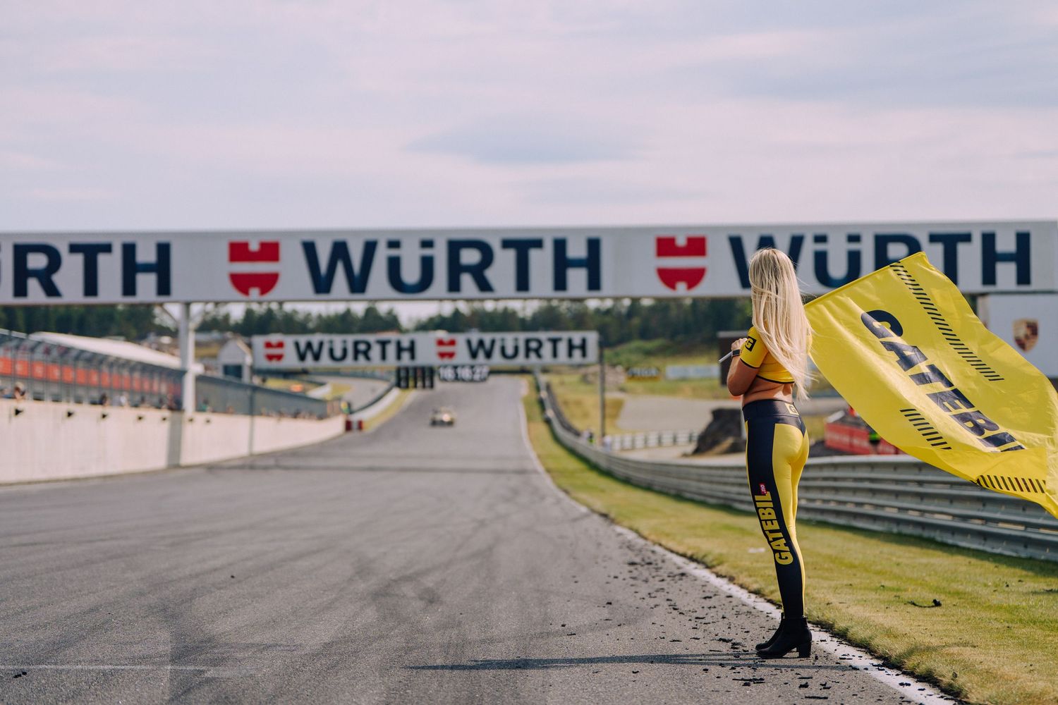 Person standing by a race track with Wurth branding visible in background.
