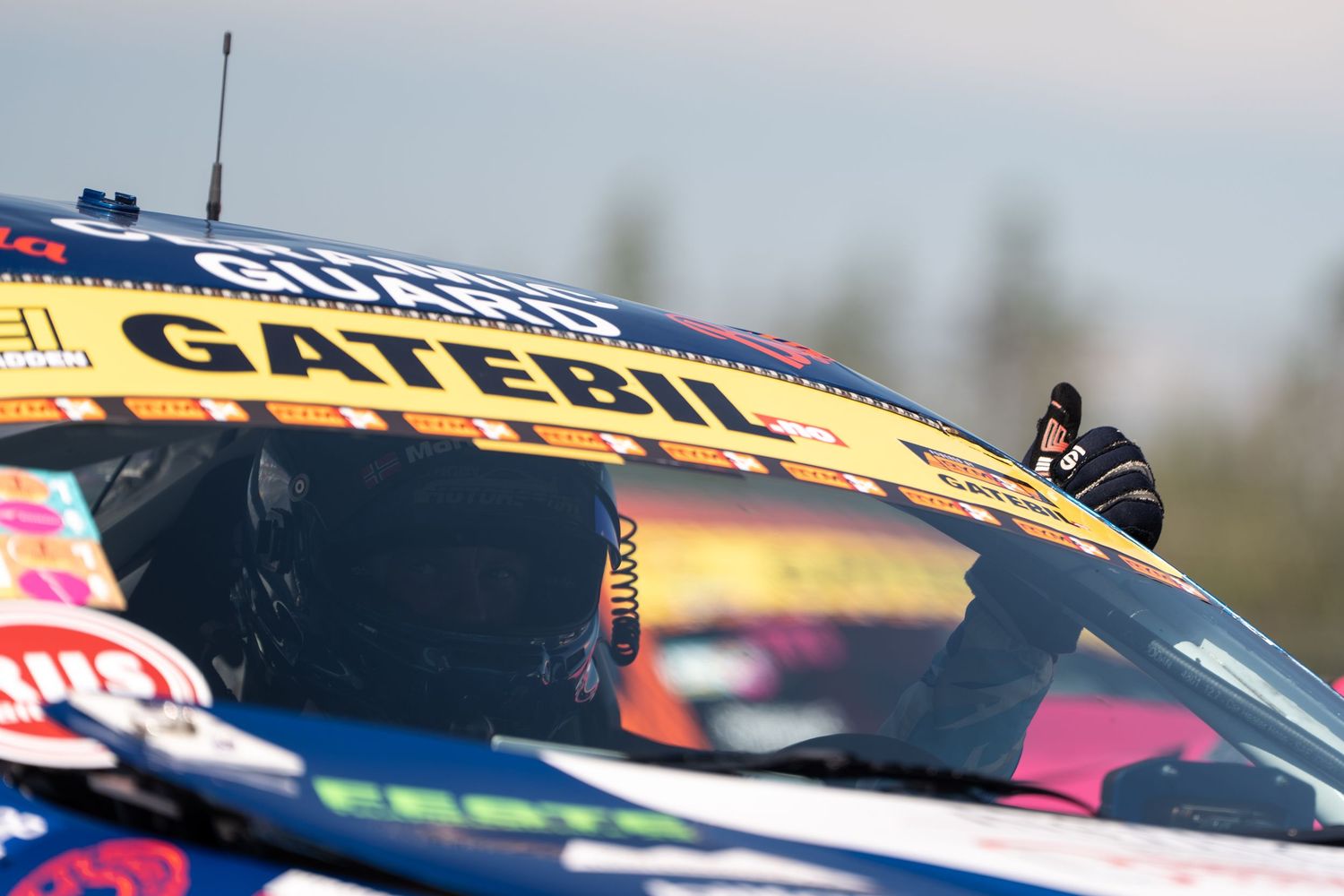 NASCAR race cars speed around the track during a competitive stock car racing event at a professional speedway.