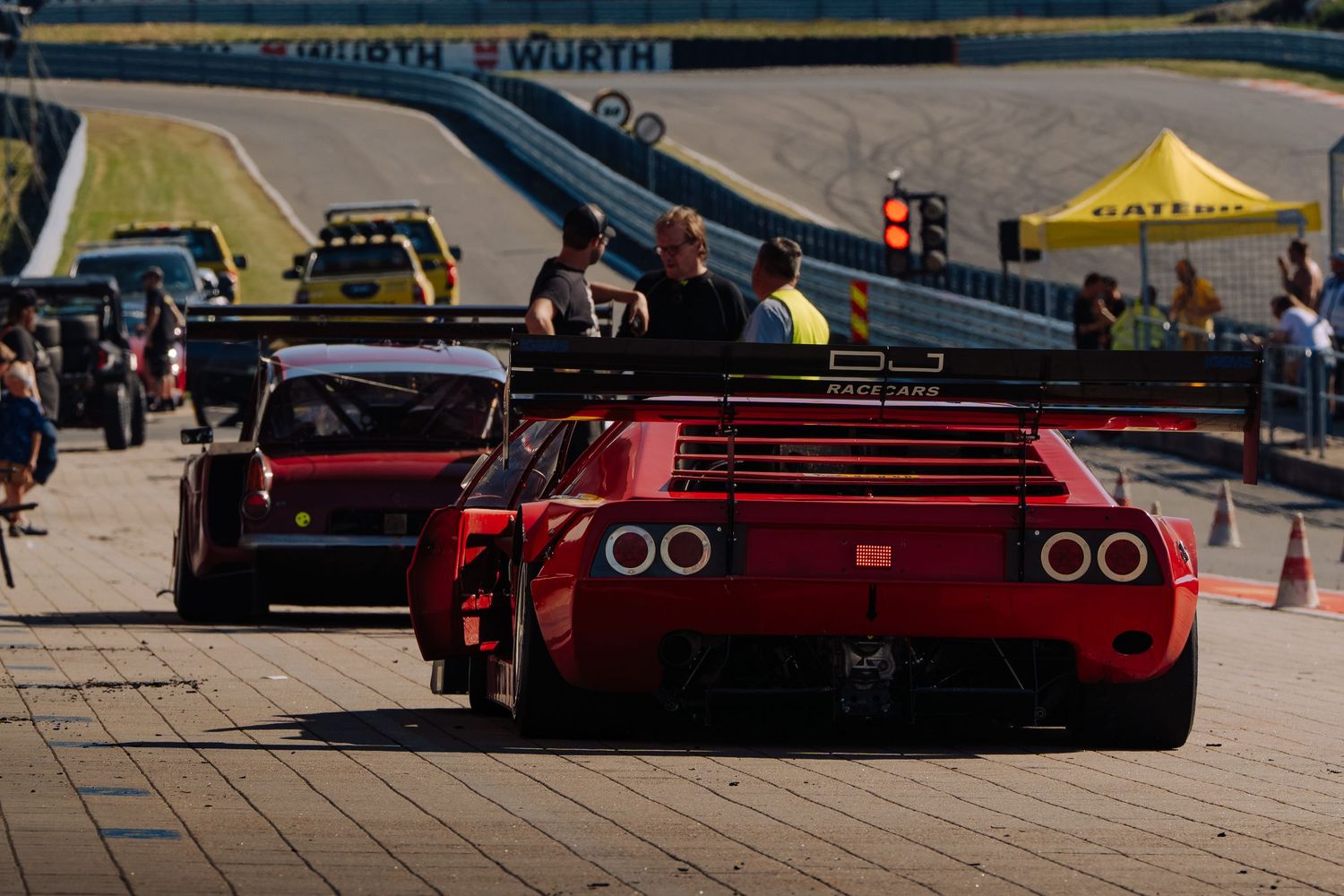 A row of red Ferrari sports cars parked in a line at a car show event.
