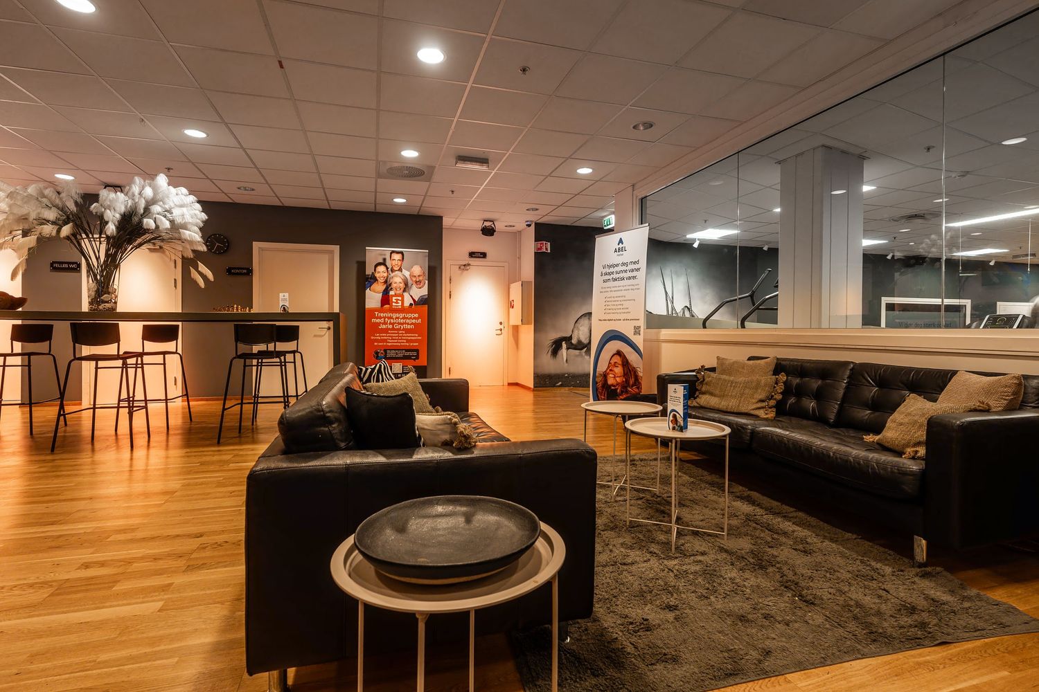 Stylish lounge space featuring leather couches, bar seating, and elegant decor with warm lighting.