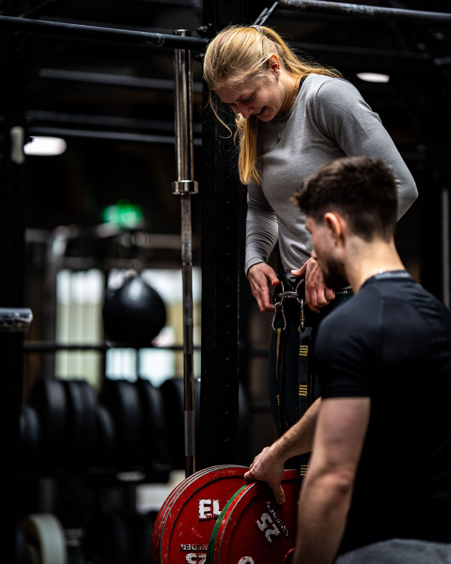 Two athletes working together with Eleiko weight plates during strength training session.