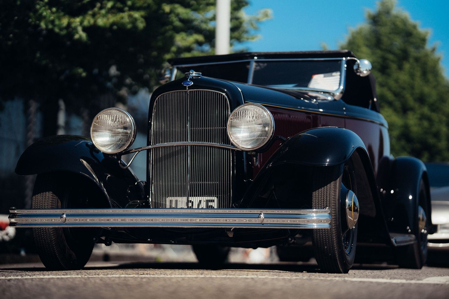 Row of classic black vintage cars photographed from a low angle showing their iconic profiles.