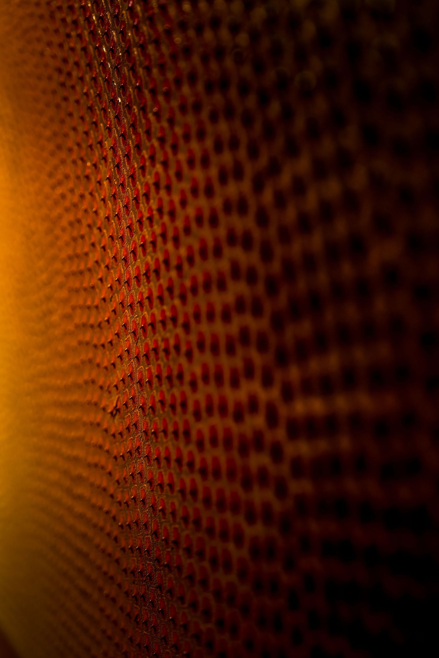 Extreme close-up of textured orange artwork showing detailed dot pattern.
