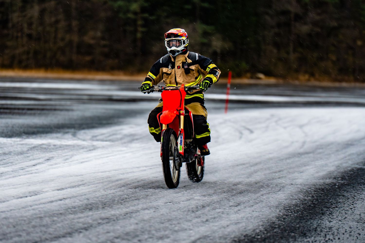 A motorcycle rider speeds across a frozen lake surface in winter conditions.