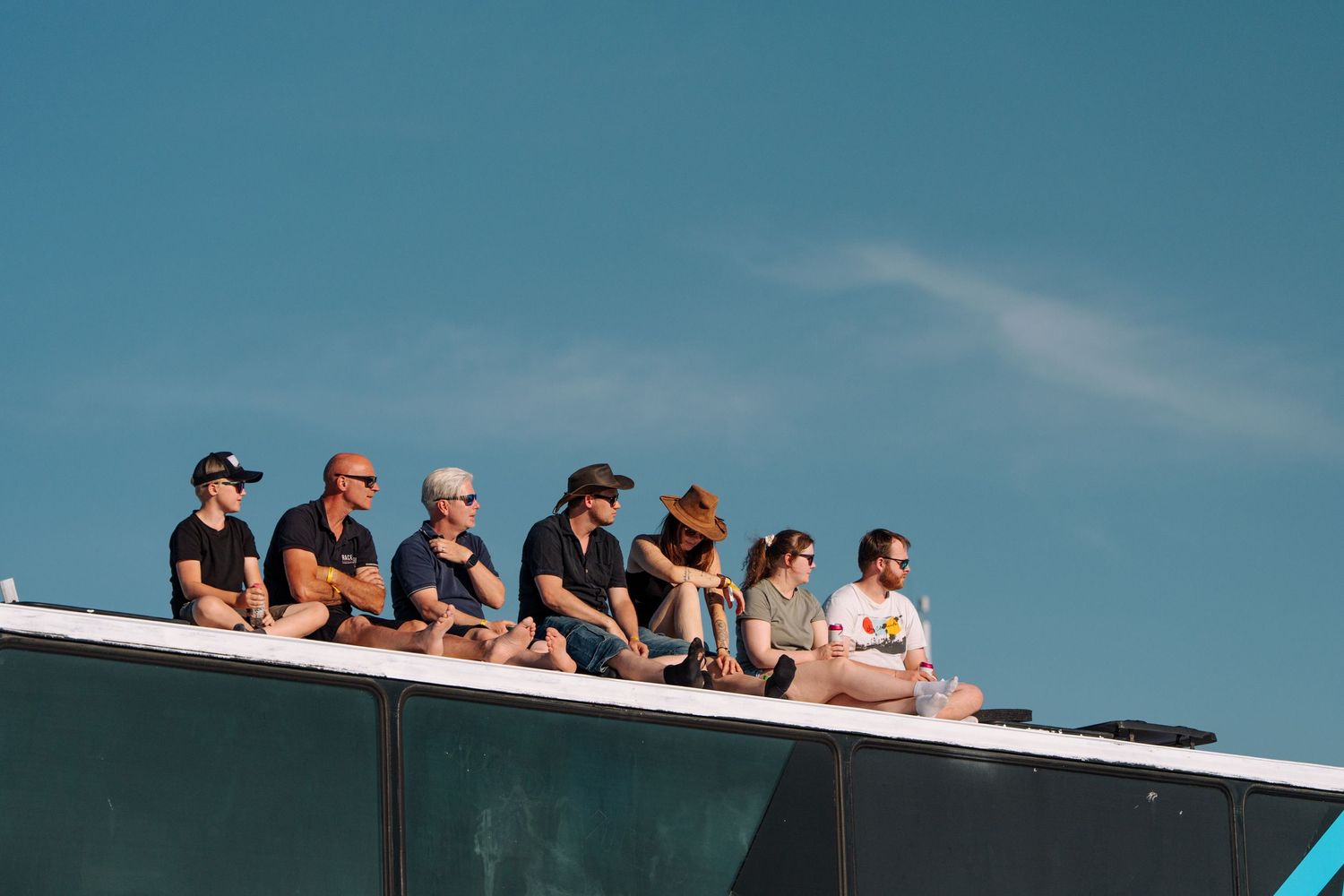 Spectators lined up watching from an elevated viewing platform against blue sky.