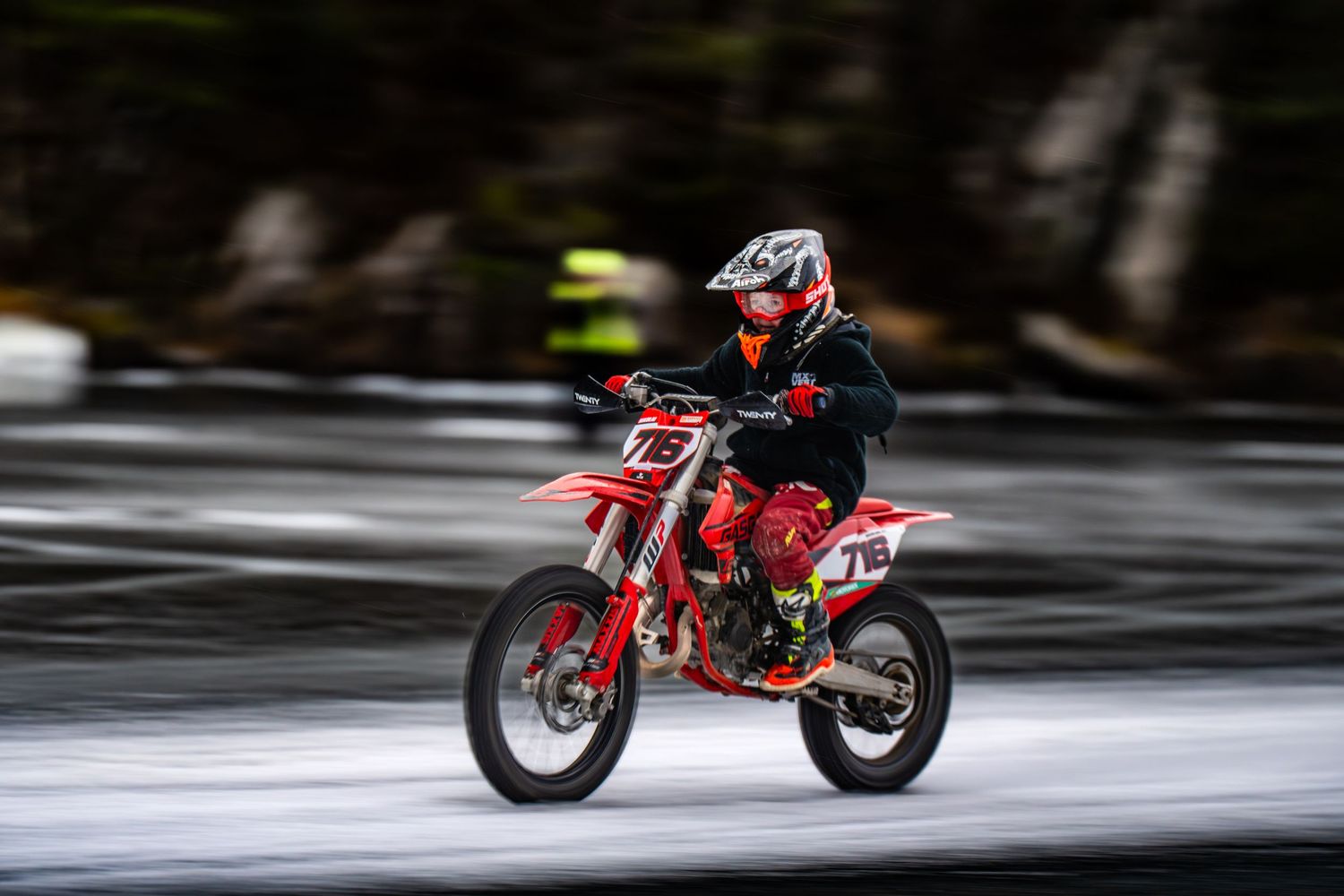 Red racing motorcycle in motion captured in multiple sequential frames showing speed and movement on a blurred track.
