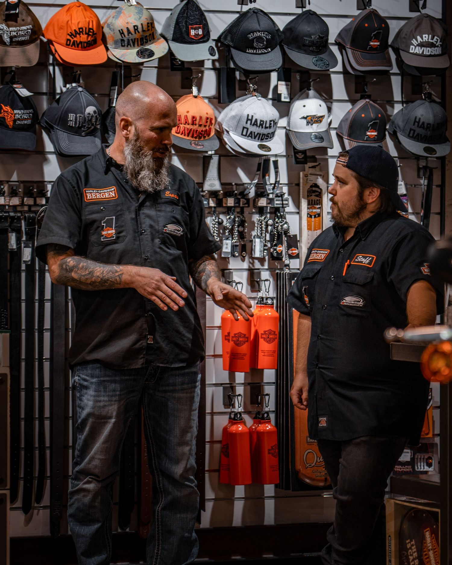 Display wall of Harley-Davidson branded hats in various colors behind a retail counter.