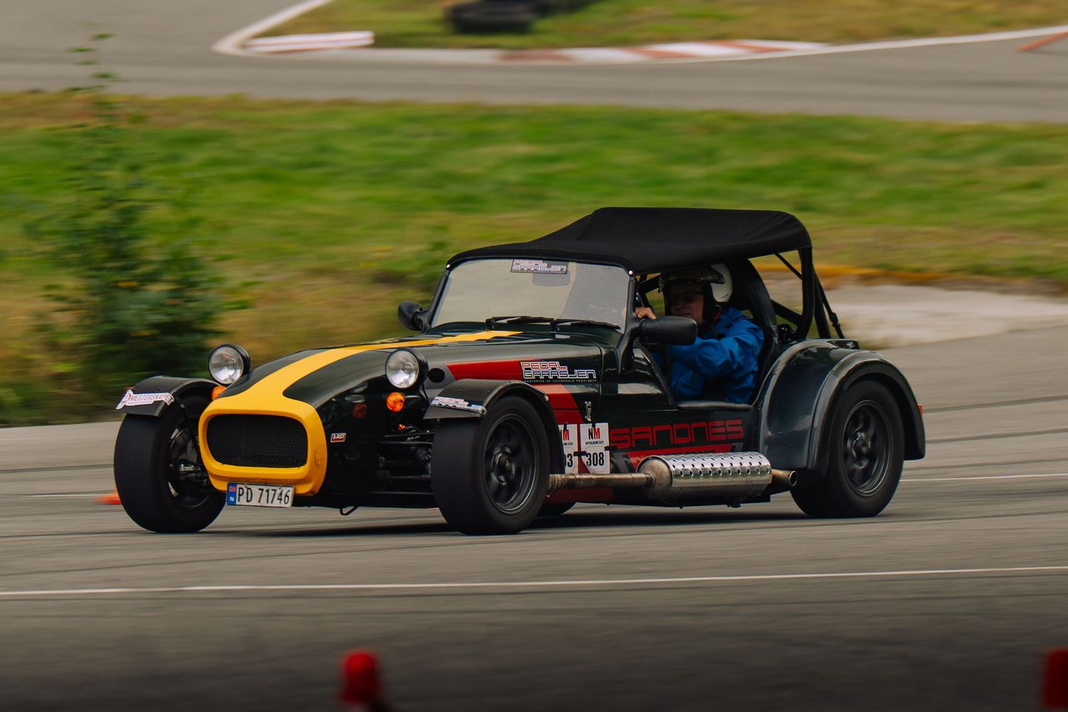 Racing cars compete on a winding racetrack during a motorsport competition event.