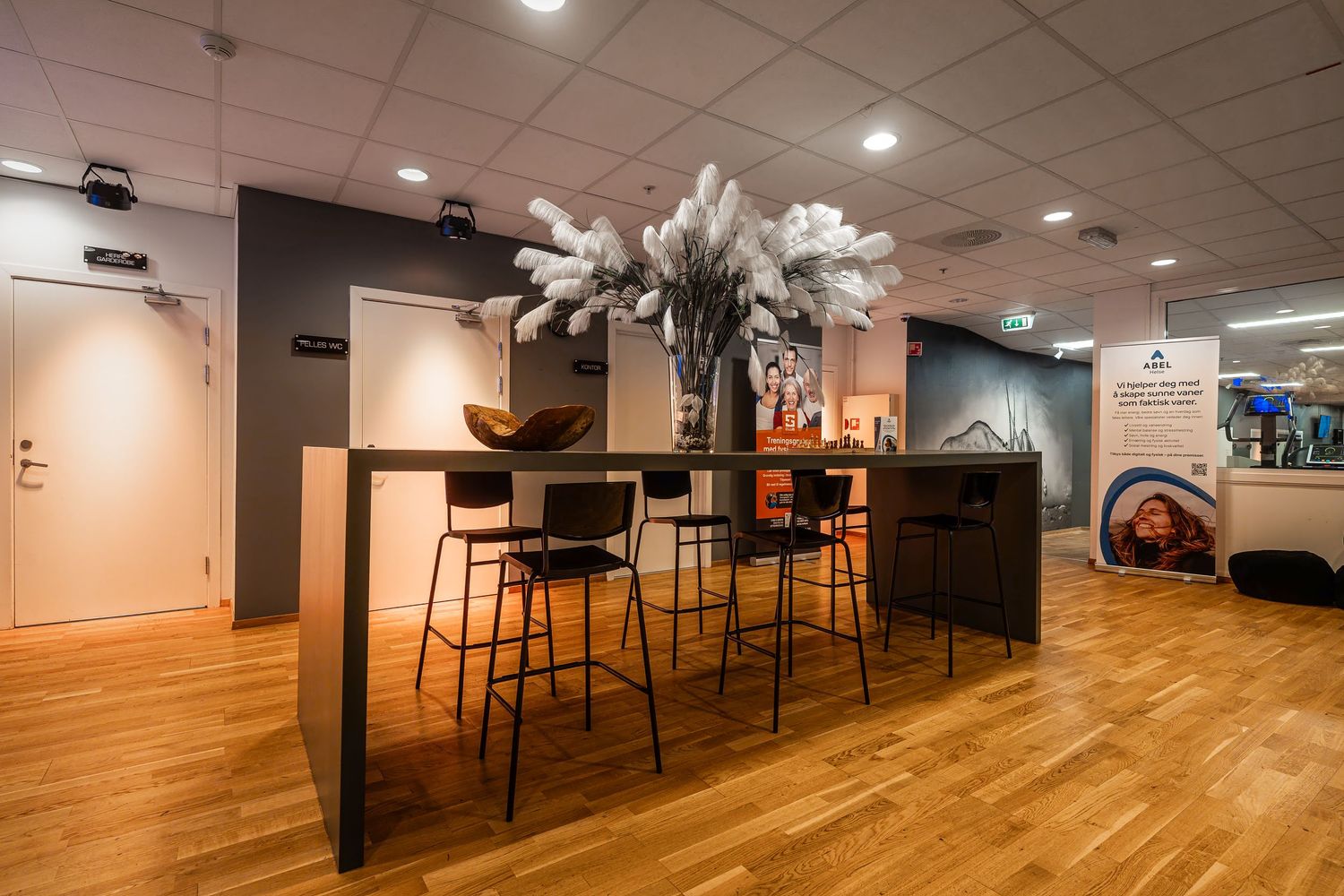 Contemporary bar area with high stools and white feather arrangements on dark wood counters.