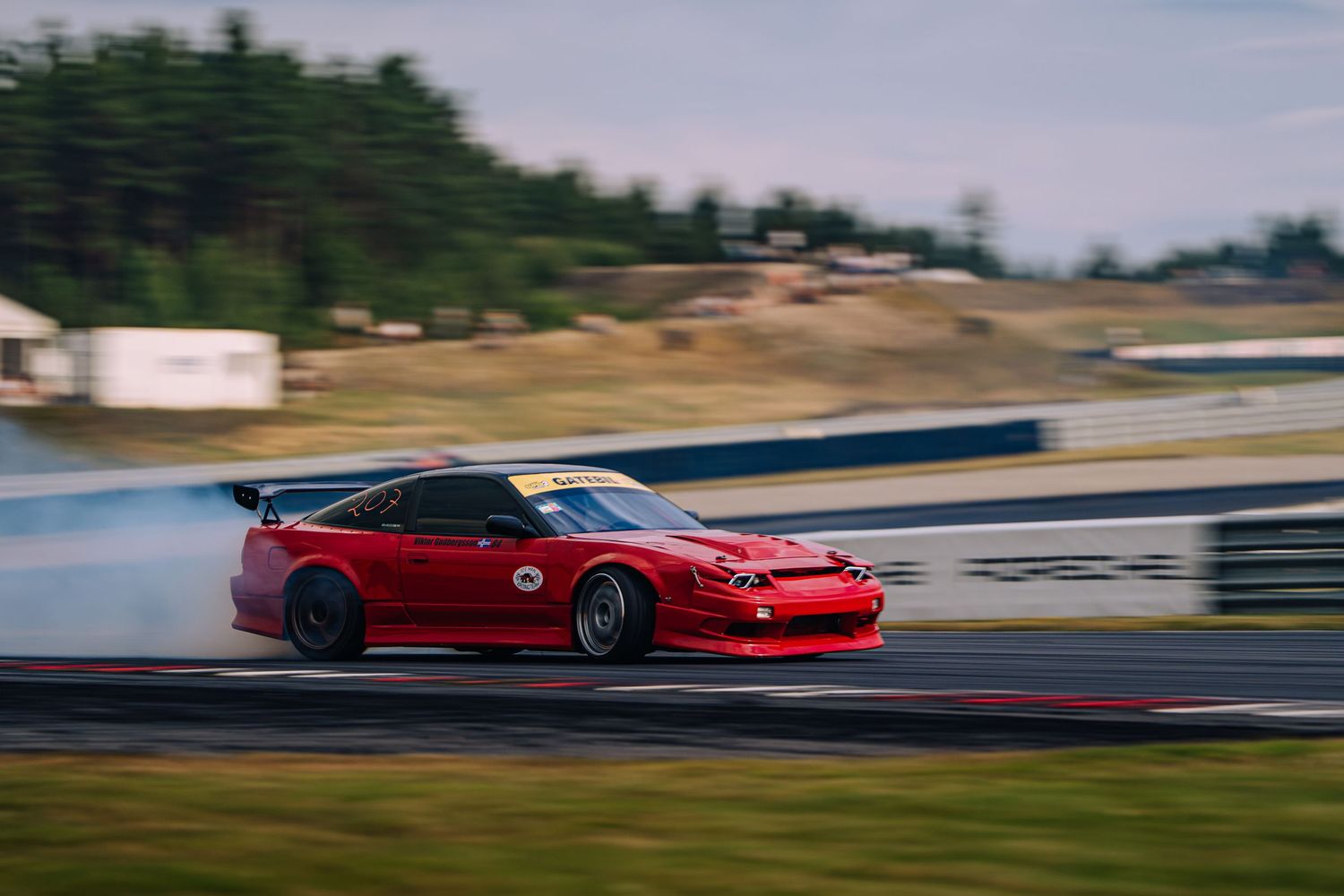 Red sports cars racing on a professional racetrack during a high-speed competition event.