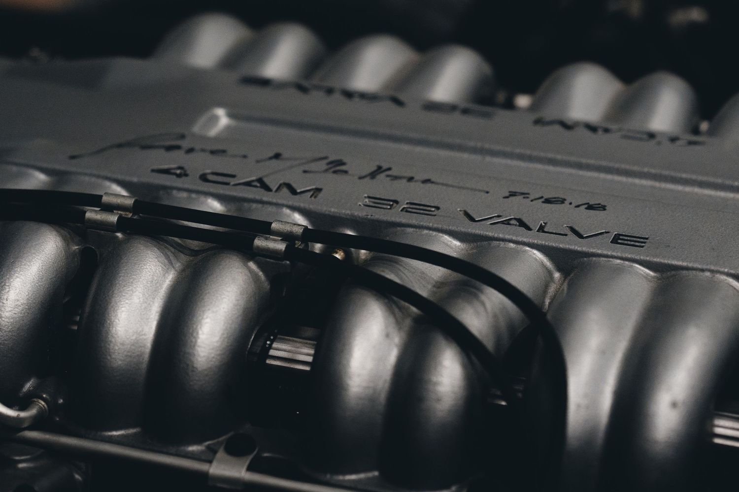 Close-up of an engine block showing multiple cylinder heads in metallic finish.