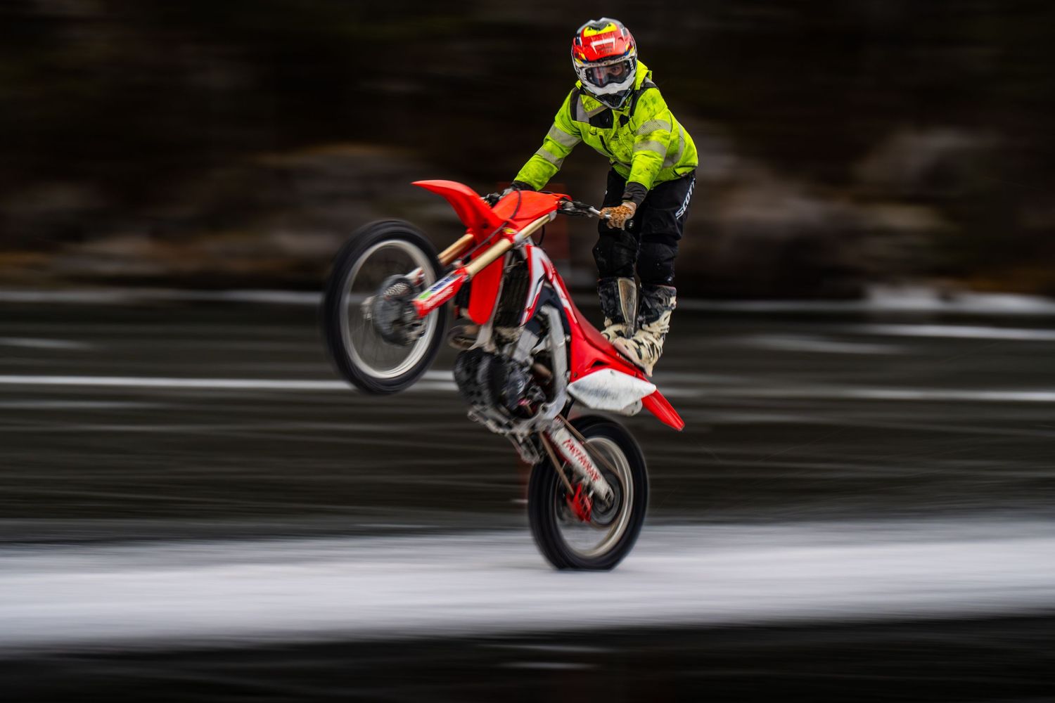 A sequence of motorcycle stunt shots showing a dirt bike performing a wheelie maneuver in motion.