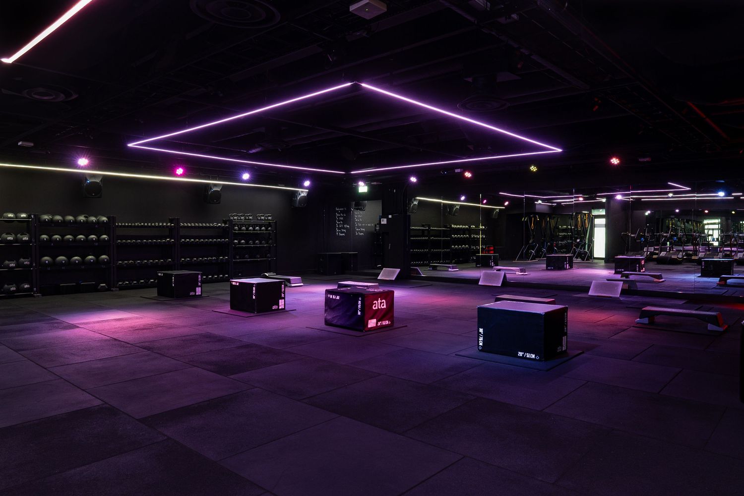 Modern nightclub exterior illuminated with purple LED strip lighting and sleek architecture.