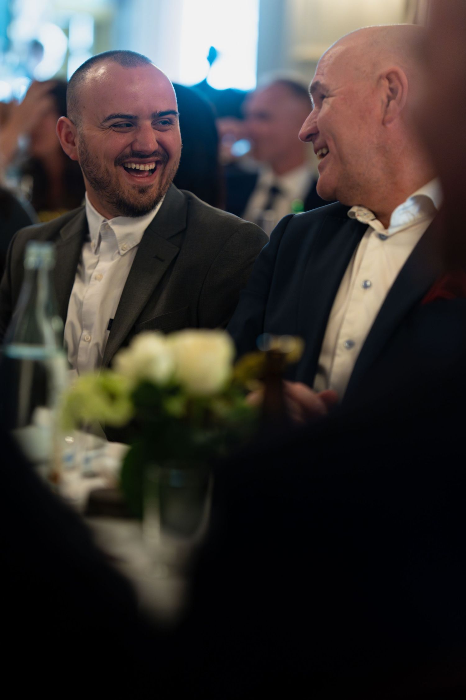 Candid shots of guests sharing laughs during formal dinner event.