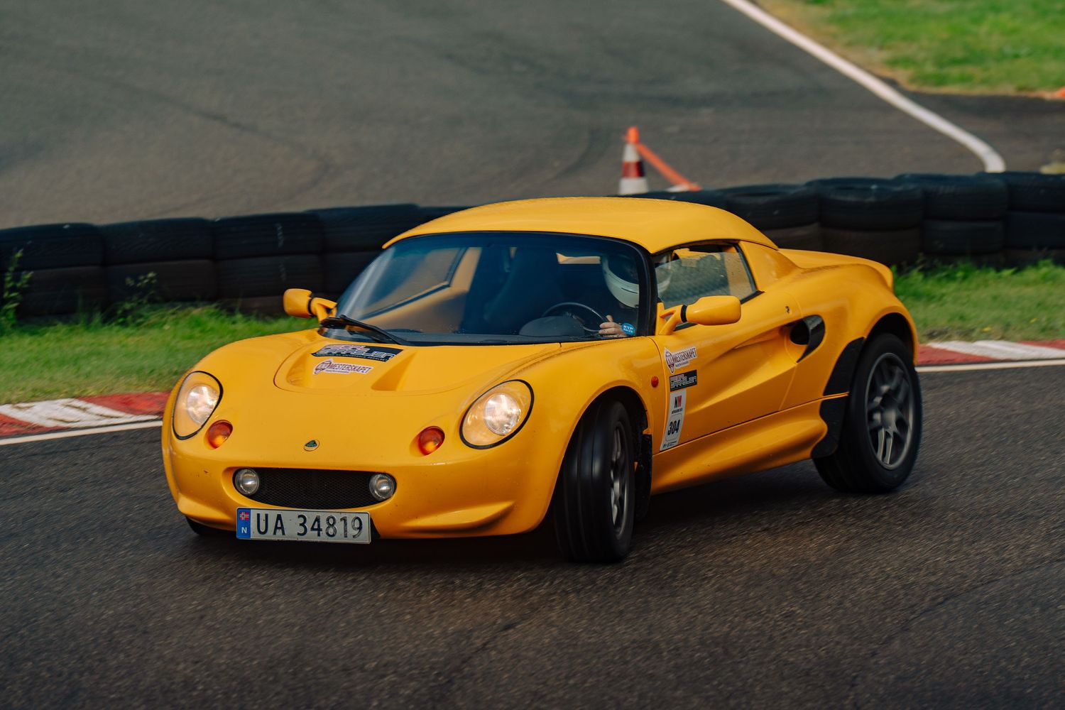 A bright yellow Lotus Elise sports car photographed from multiple angles on a racetrack.