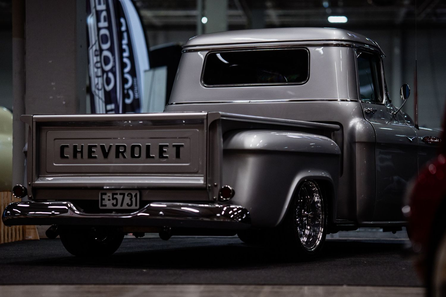 Classic Chevrolet trucks displayed in a dimly lit automotive showroom.