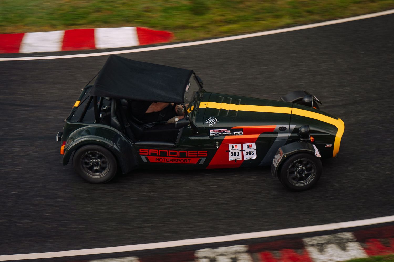 Race cars compete on a professional racing circuit during a motorsport competition event.