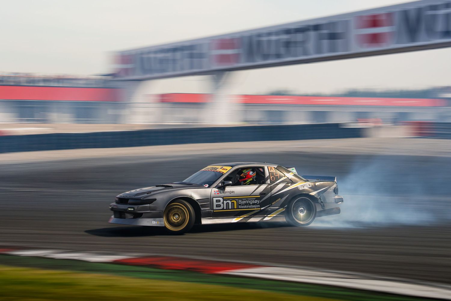 Formula One race car drifts around a track corner during a high-speed competition.