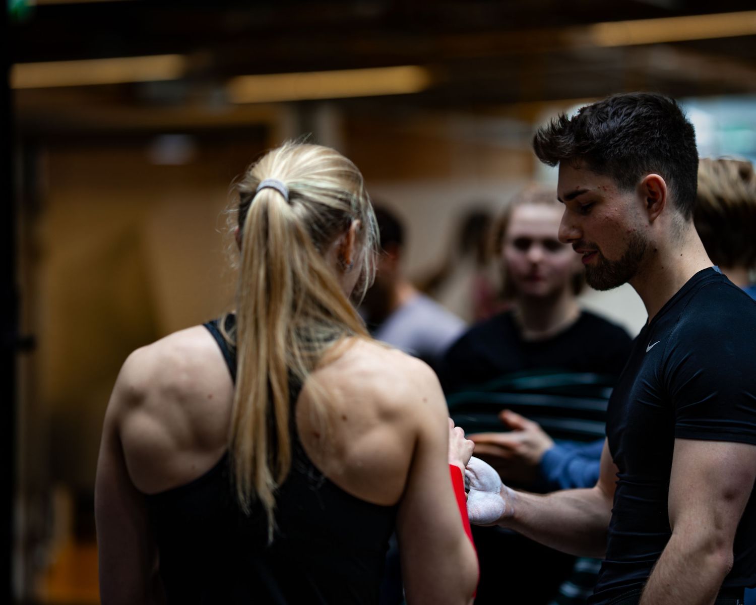 Athletes working out together in a modern fitness facility with dark lighting.