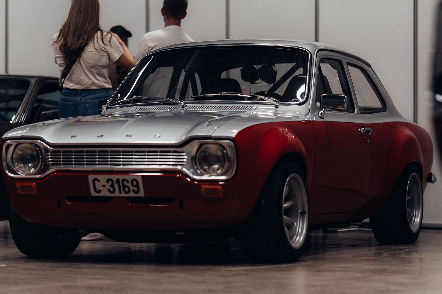 Collection of vintage cars displayed in a minimalist white showroom setting.