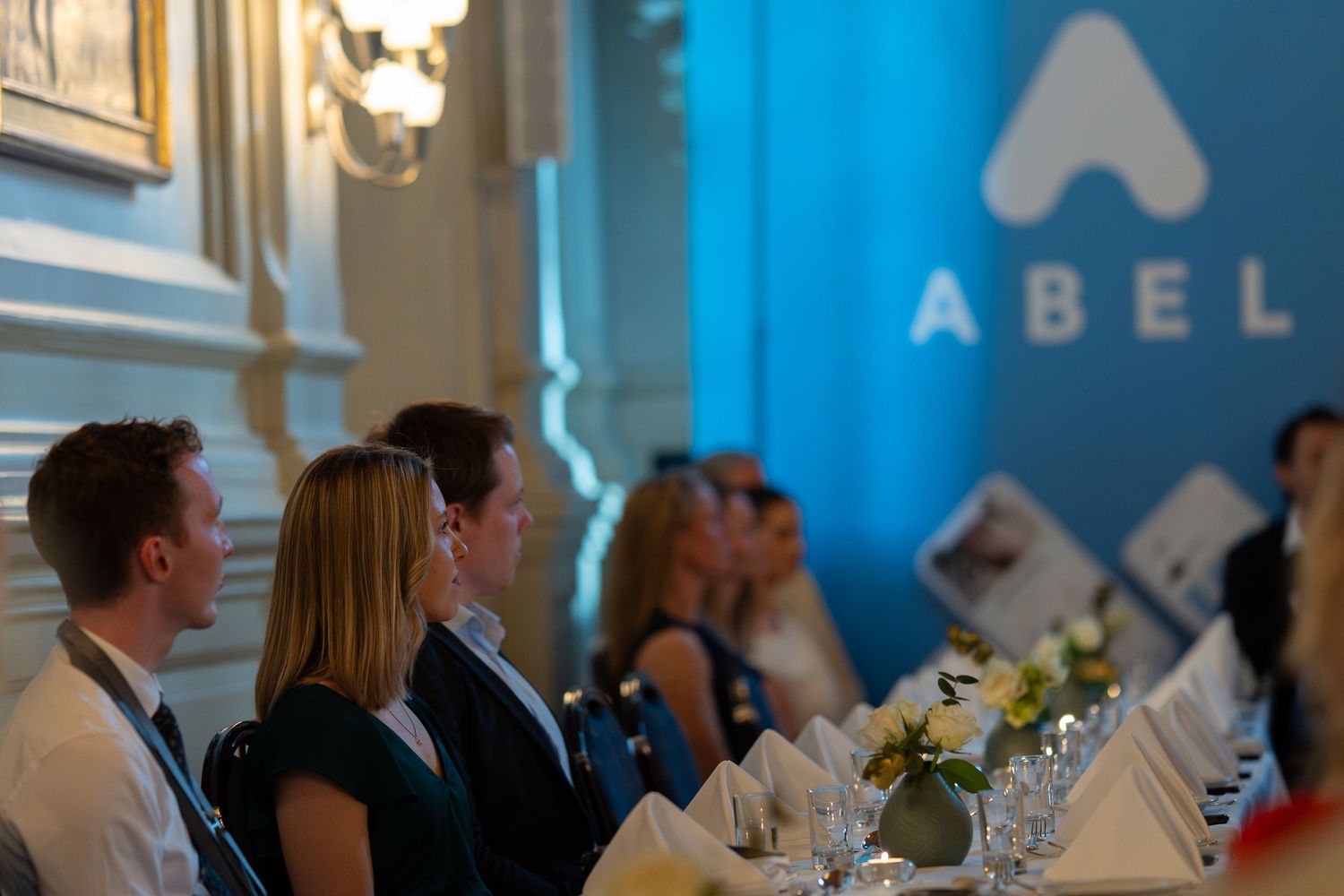 Corporate event setup with ABEL company branding and formal table settings.