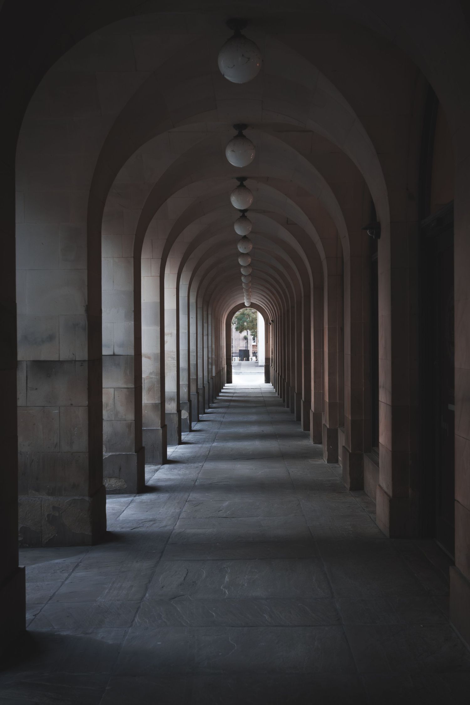 An arched stone corridor extends into the distance creating a symmetrical architectural tunnel perspective.