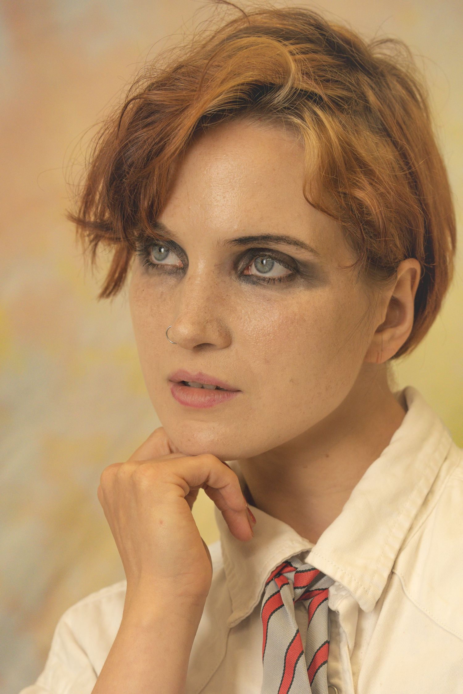 Soft portrait in warm tones featuring thoughtful expression and white collar.