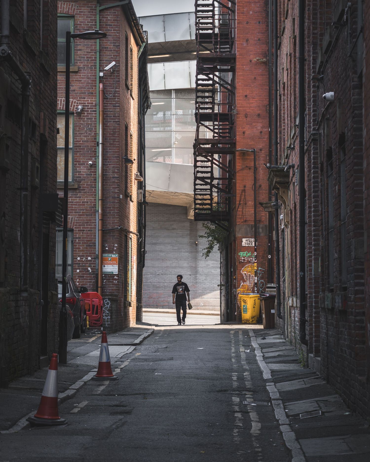 A series of dark urban alleyways with red brick buildings and a moody, atmospheric composition.