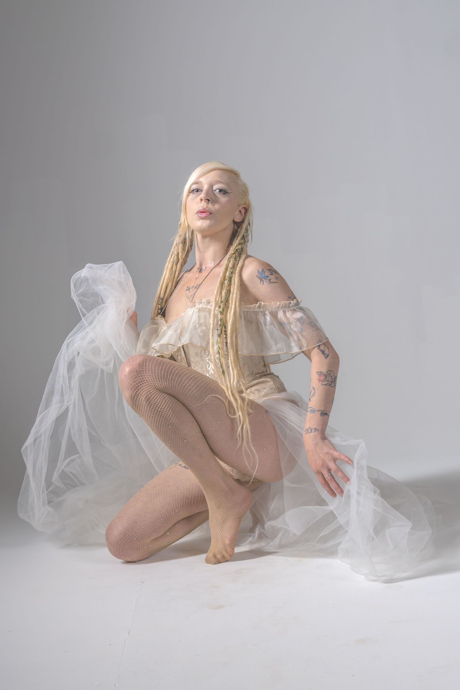 Artistic photo series featuring a dancer in beige bodysuit with white fabric performing graceful poses on light background.