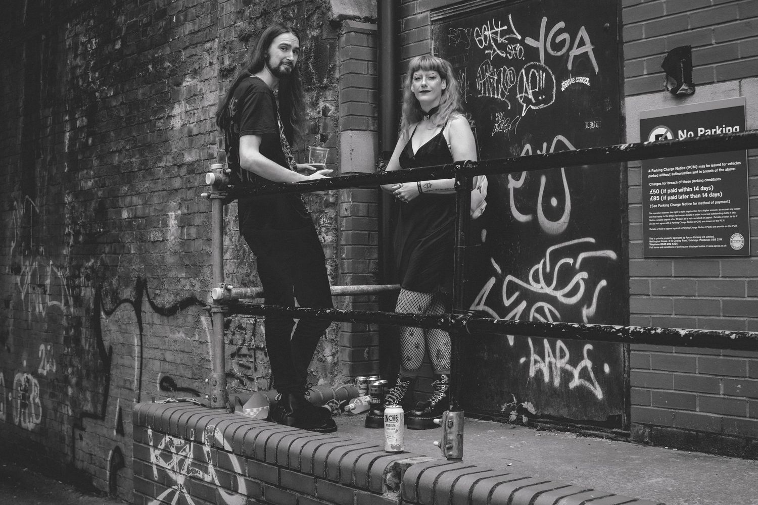 Urban street photography showing brick walls with graffiti in monochrome.
