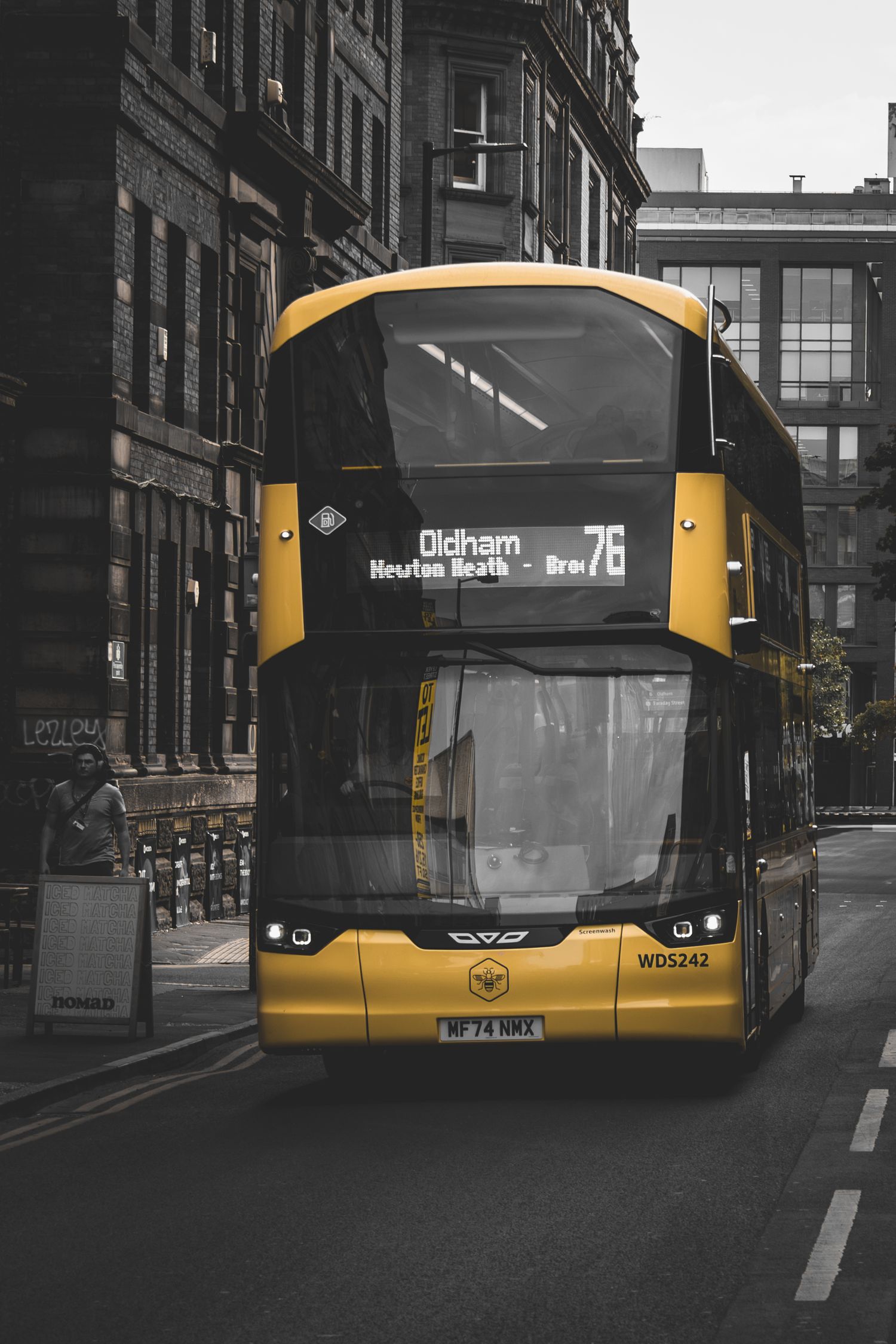 Yellow and gray city bus on a moody urban street photographed from multiple angles in monochromatic style.