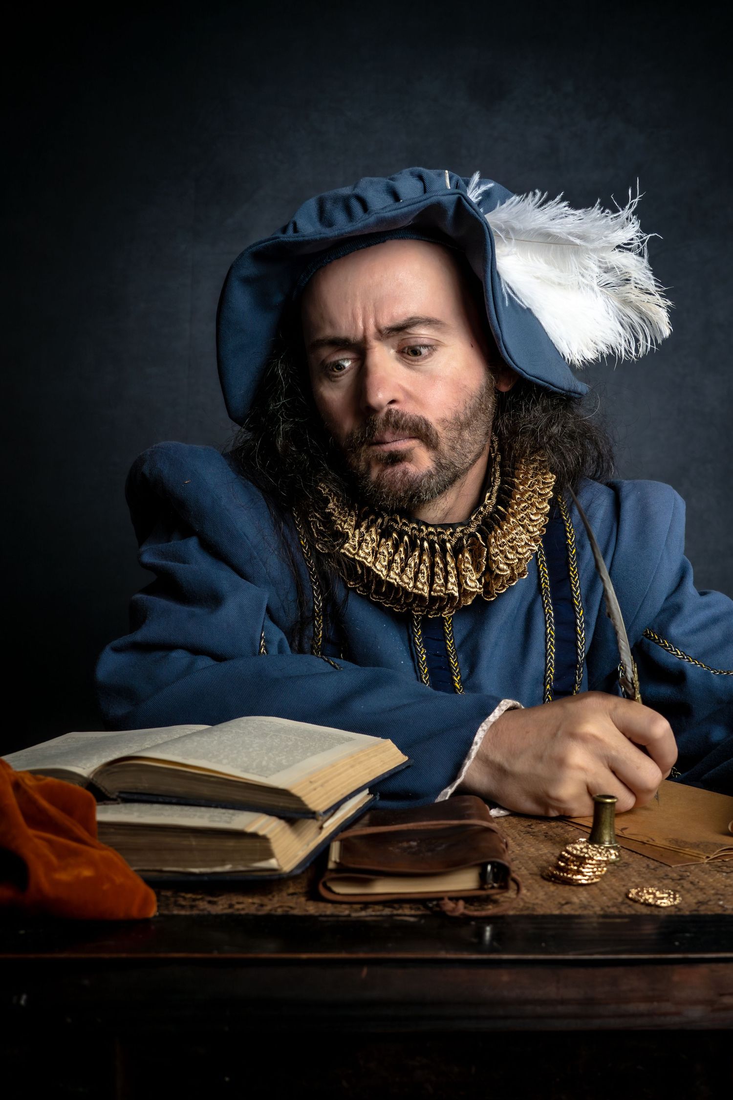 Period-dressed figure in blue with ruffled collar writes in antique book at wooden desk.