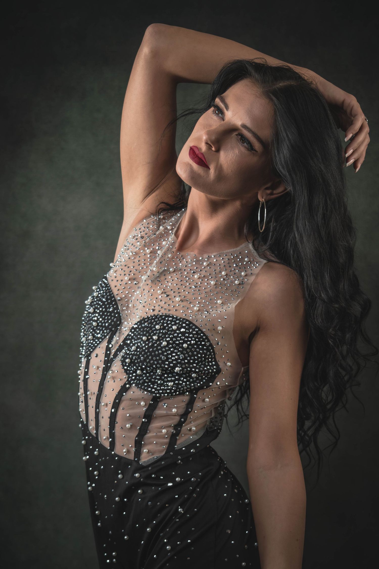 Glamorous portrait series showing a sparkling black evening gown with sheer beaded bodice in dramatic lighting.
