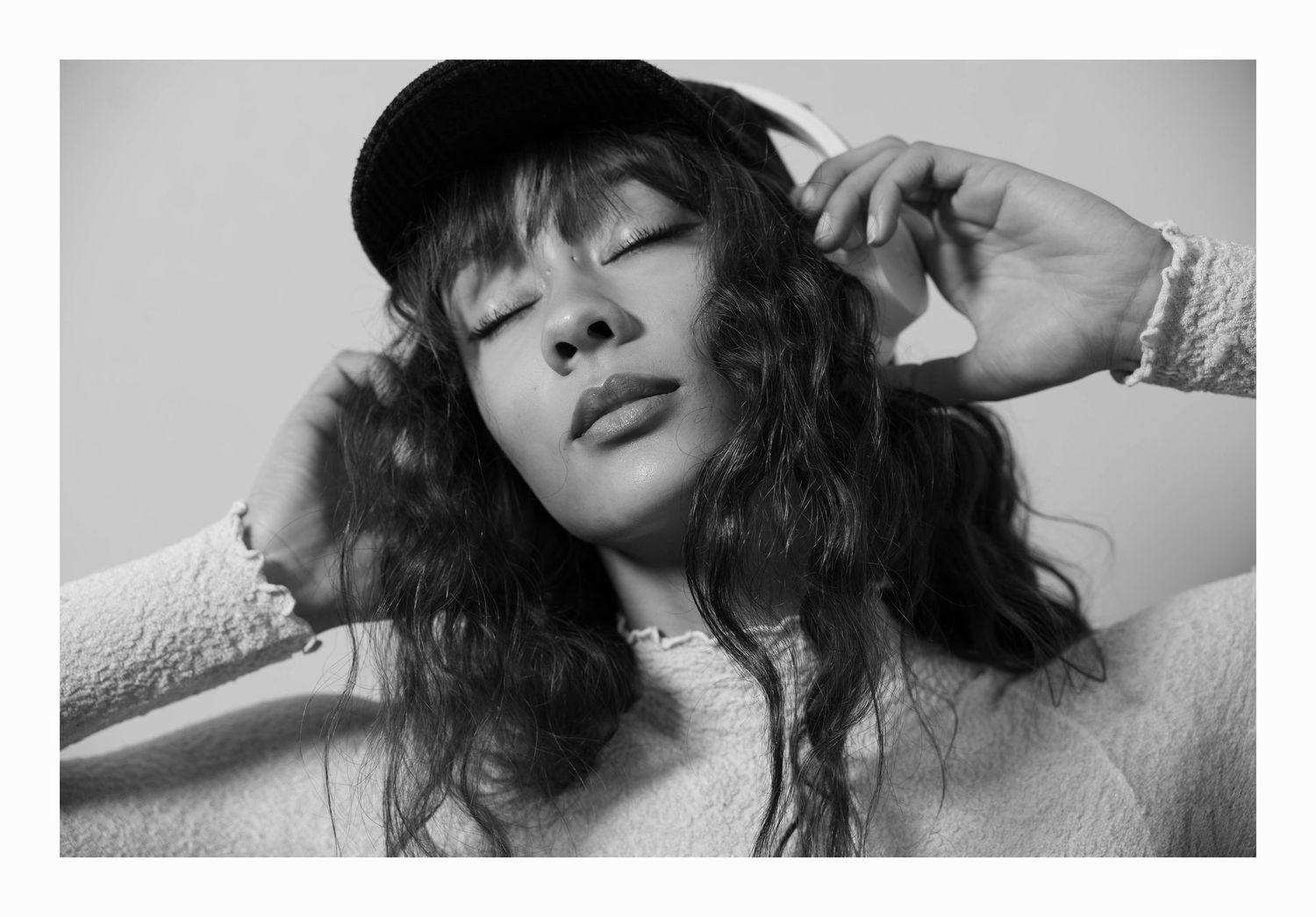 A black and white artistic portrait series showing close-up views of someone with dark hair and expressive poses.