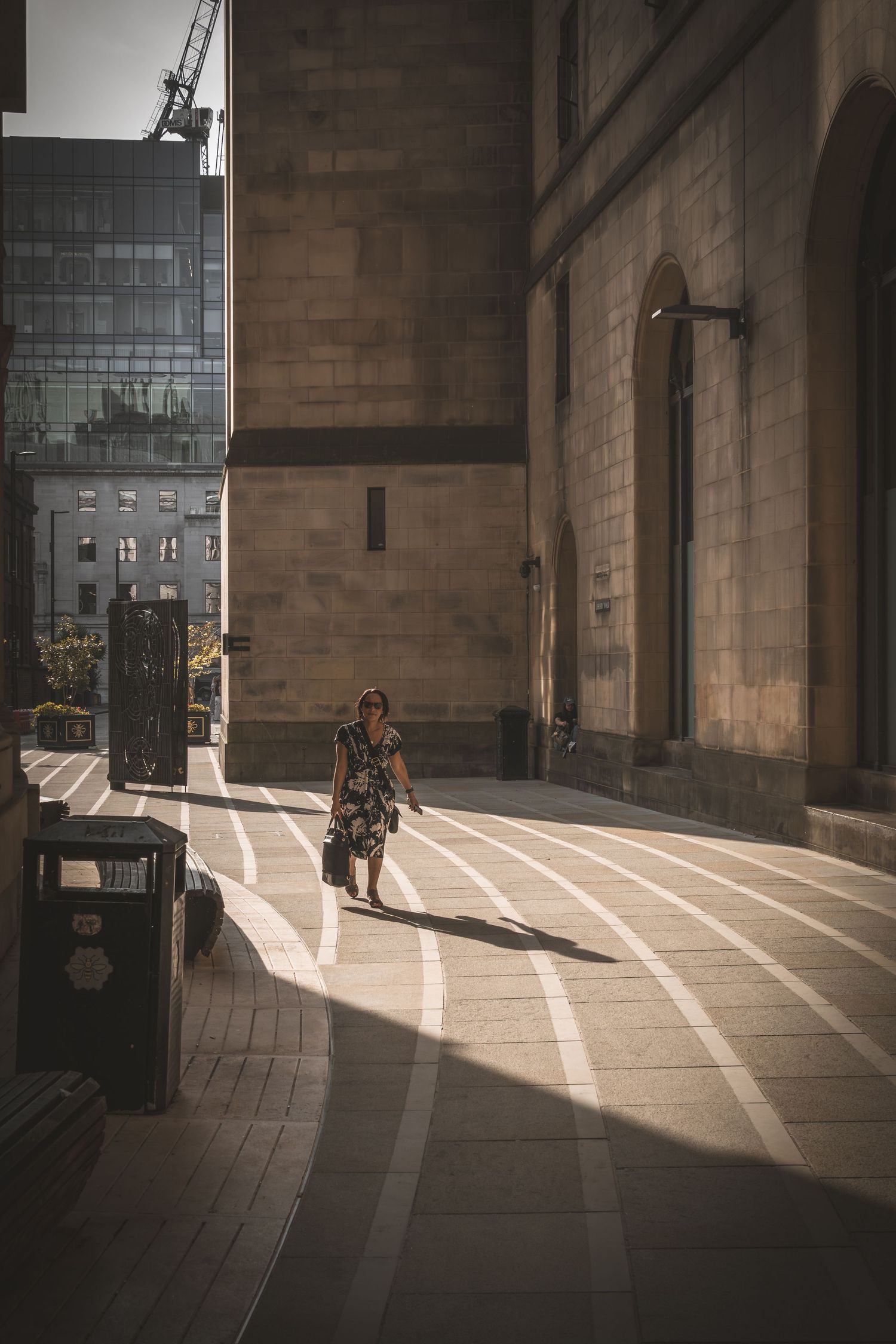 Sunlight streams through windows casting dramatic shadows and light patterns across a concrete interior walkway.