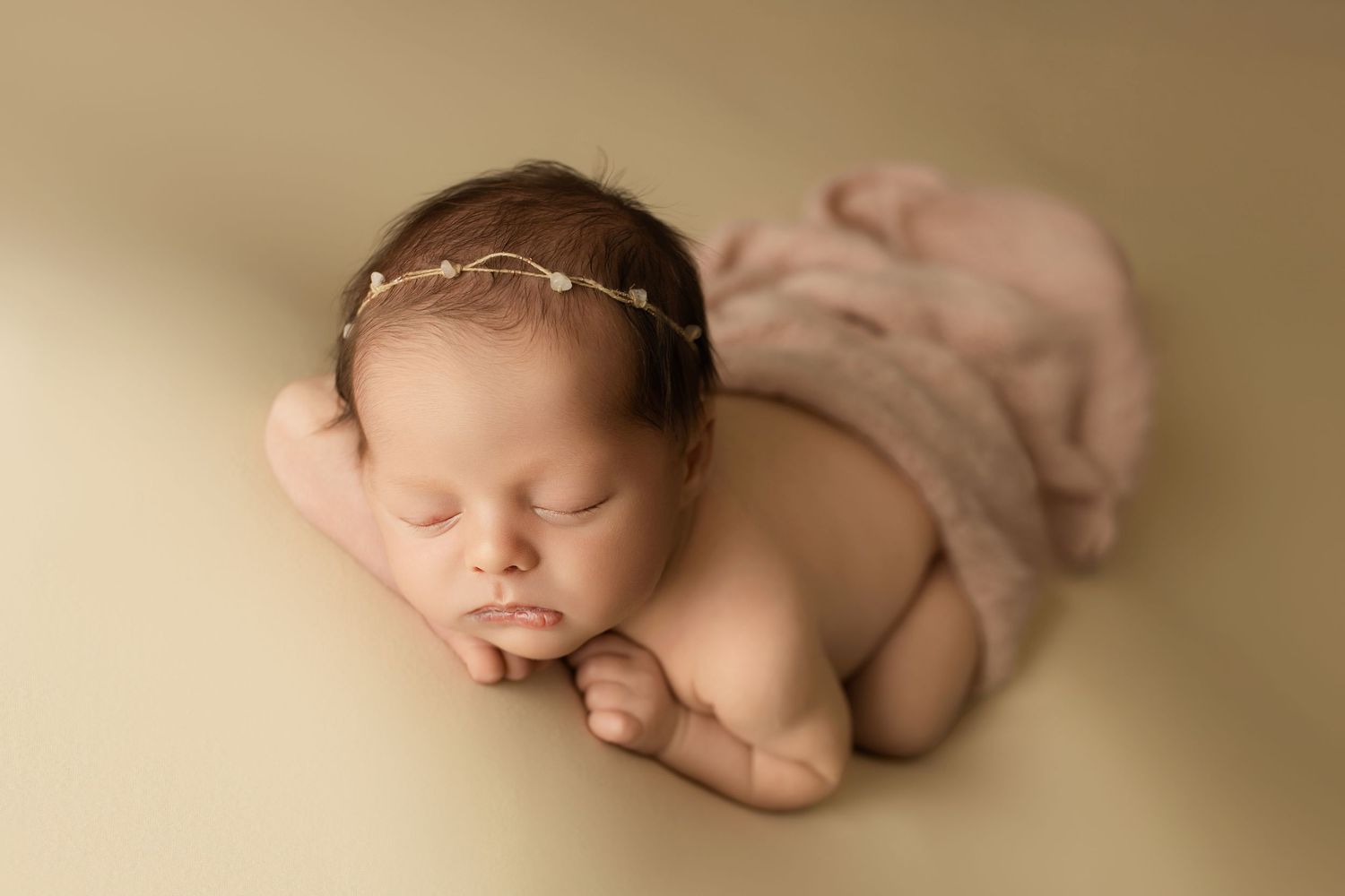 Close up portrait of sleeping baby with creamy beige background.