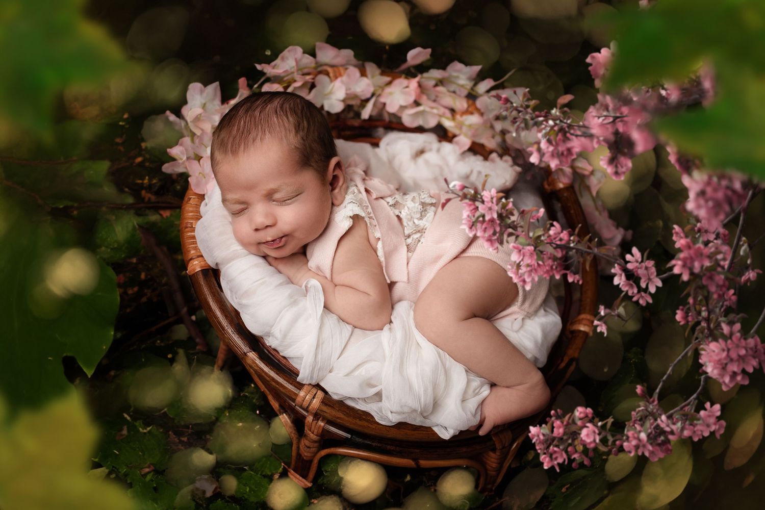 Series of artistic baby photos with pink cherry blossoms and floral arrangements.