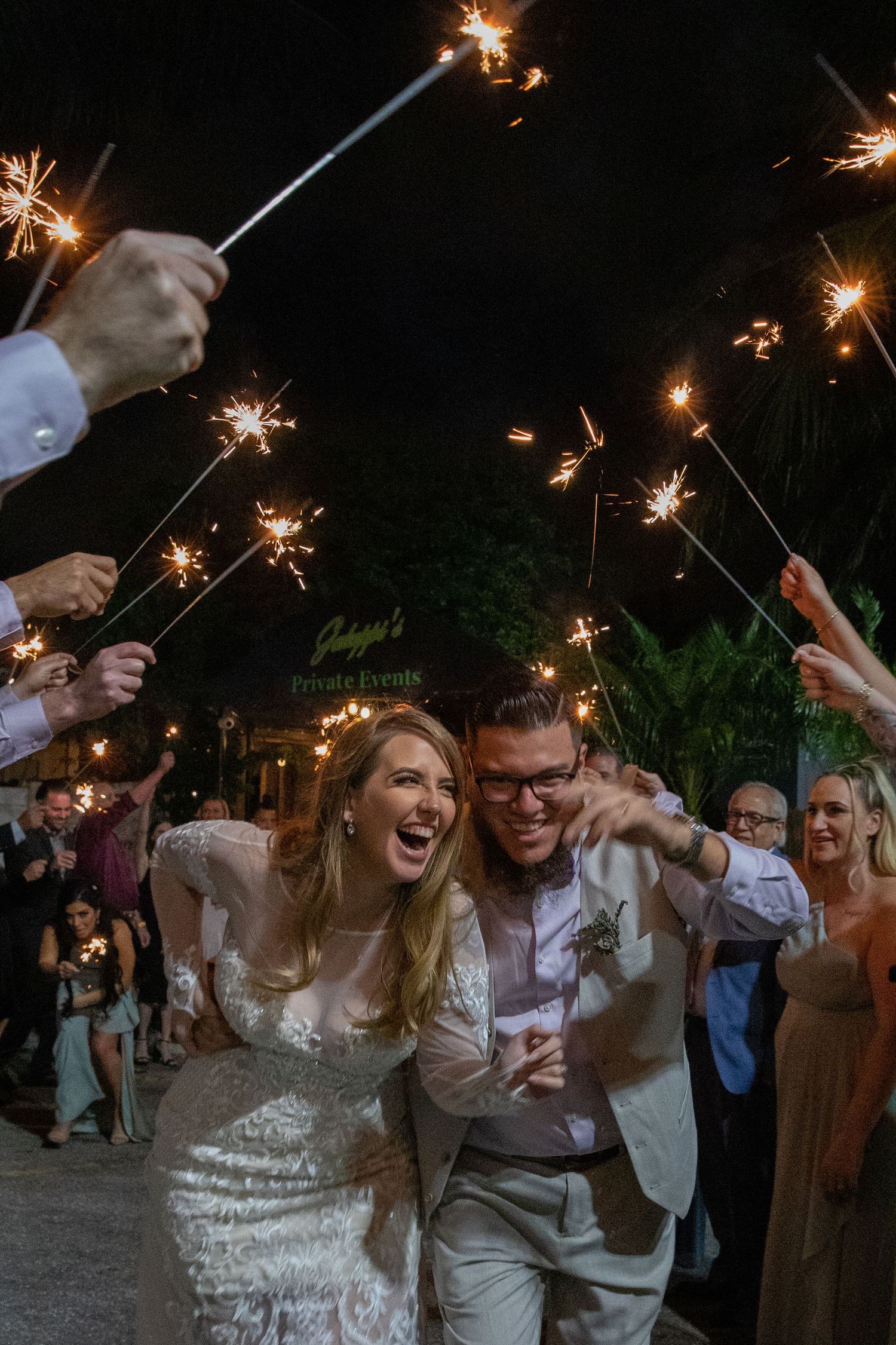 A joyful celebration at night with sparklers creating a magical atmosphere as people dance and celebrate together.