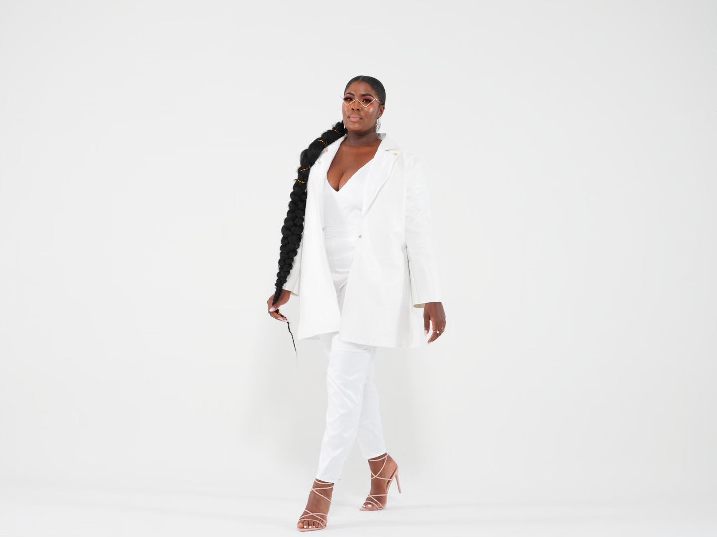 Model wearing an elegant white blazer suit with a sheer blouse poses in multiple views against a studio backdrop.