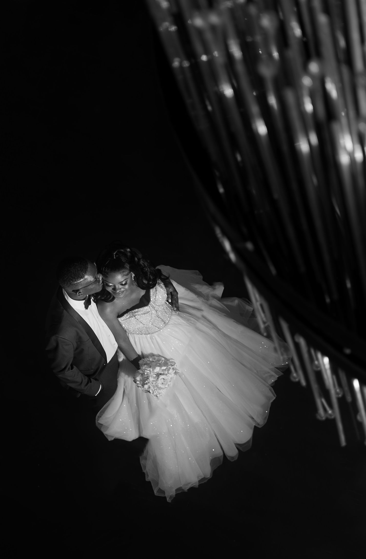 A dramatic black and white series of dance poses shown in silhouette against streaks of light.