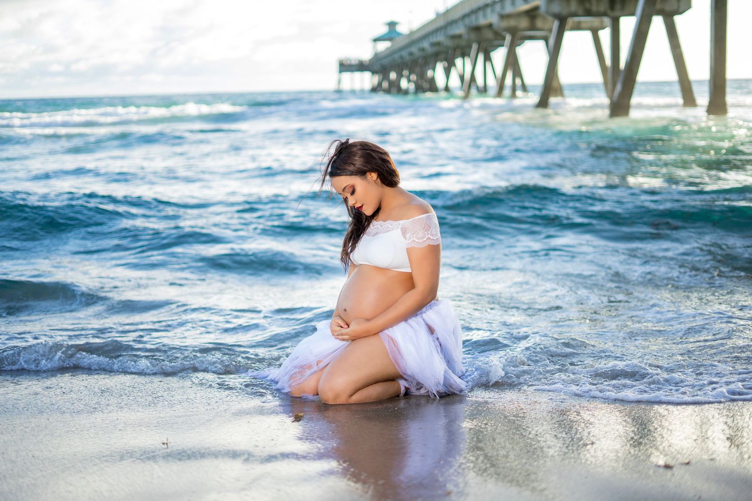 A collection of maternity photos taken at sunset on the beach with waves lapping at the shore.